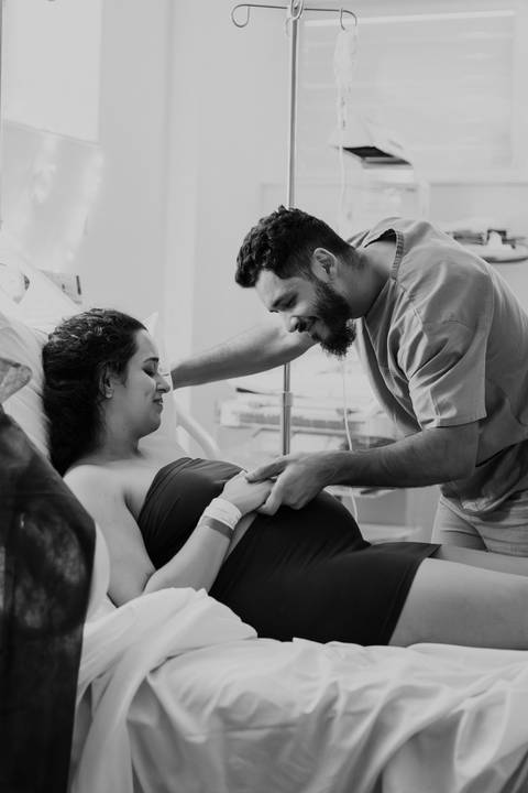 Foto em preto e branco do casal sorrindo no pré-parto'