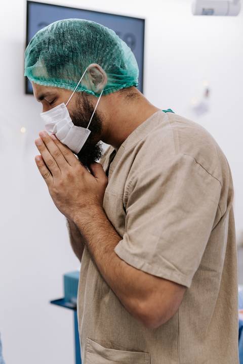 Foto do pai em oração na sala de parto'