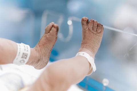 Foto do detalhe dos pés do bebê no berço aquecido'