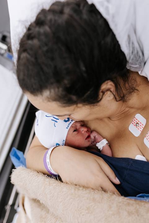 Foto do contato pele a pele entre mãe e bebê'