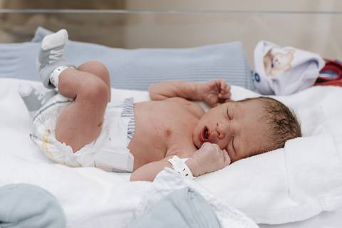 Foto do bebê deitado no berço após os primeiros exames'