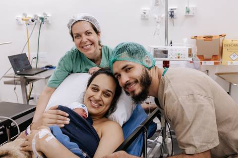 Foto da família reunida com a equipe médica no hospital'