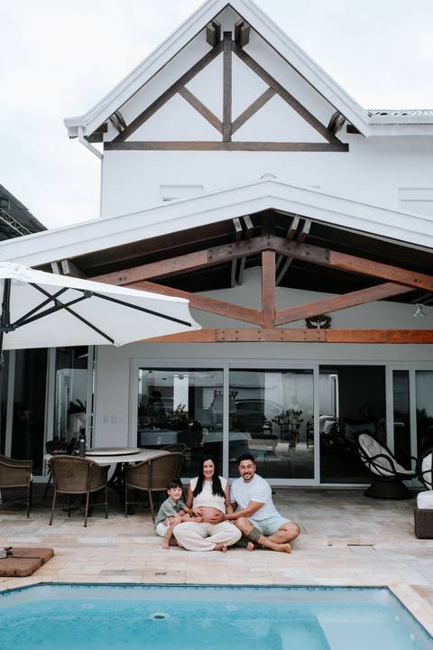 Foto da fachada da casa de praia com a família para ensaio gestante externo'