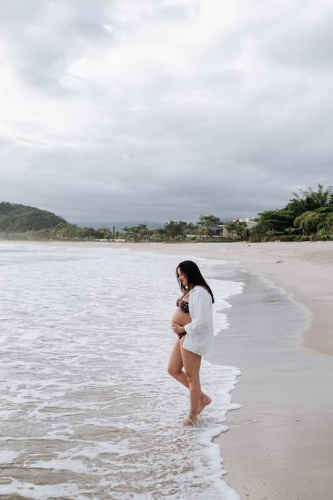 Foto da gestante de perfil na beira da água'