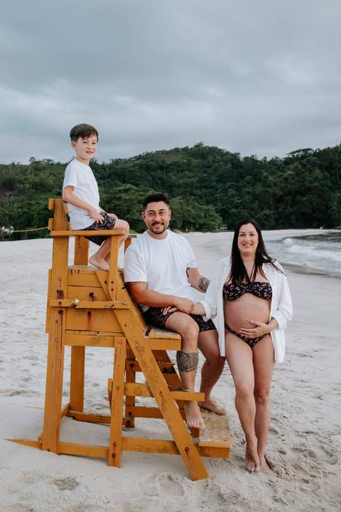 Foto da família reunida em cadeira de salva-vidas durante ensaio externo'