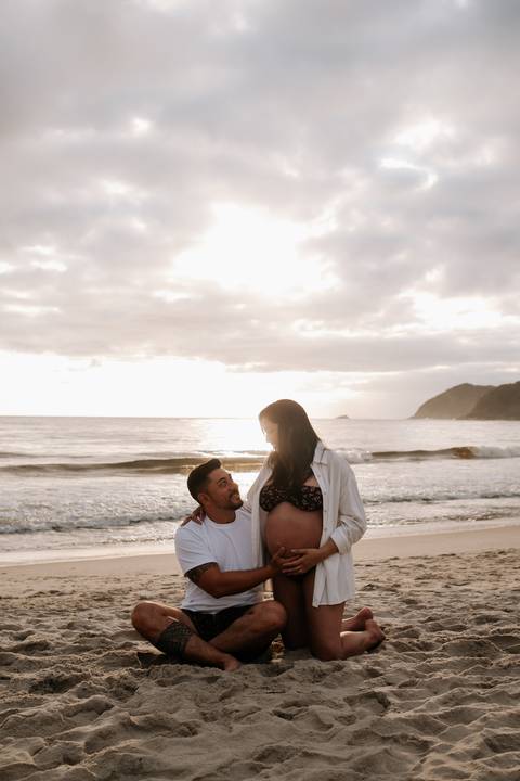 Foto do casal em silhueta na praia durante o pôr do sol'
