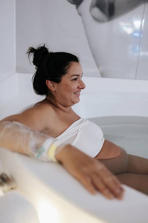 Foto aproximada da gestante na banheira durante o trabalho de parto.'