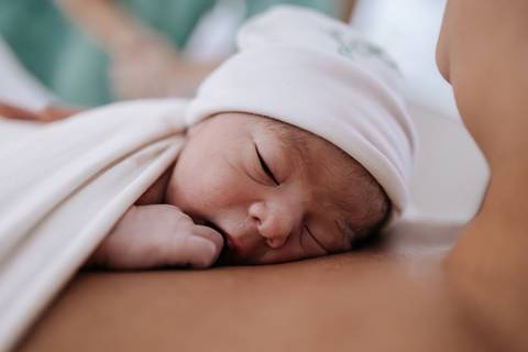 Foto do bebê dormindo tranquilamente após os primeiros cuidados.'