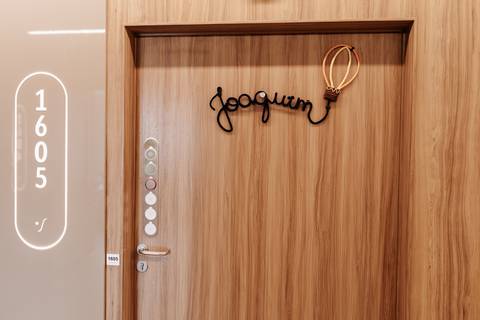 Foto da porta do quarto de maternidade com enfeite decorativo.'