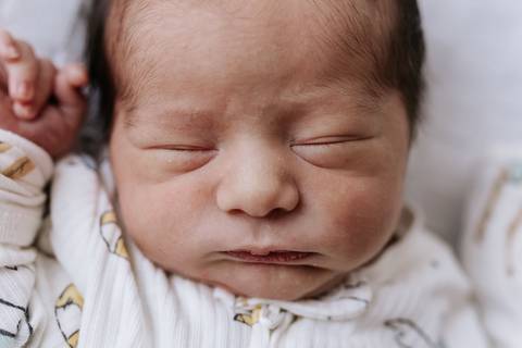 Foto aproximada do rosto do bebê dormindo tranquilamente.'