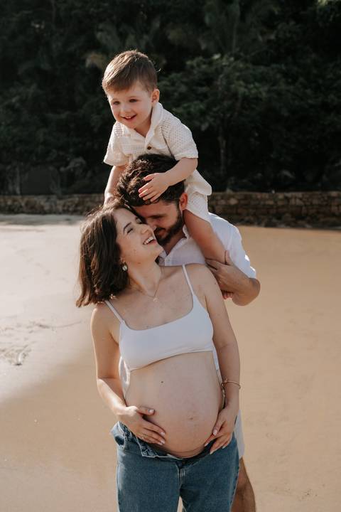 Foto da família reunida com o filho nos ombros do pai.'
