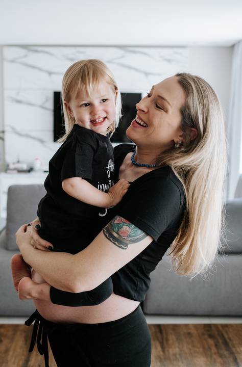 Foto da mãe abraçando a filha no ensaio gestante lifestyle.'