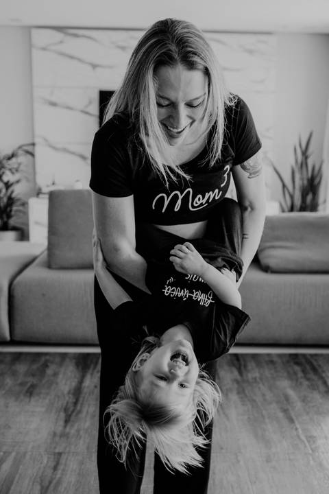 Foto em preto e branco do detalhe da filha abraçada à mãe.'