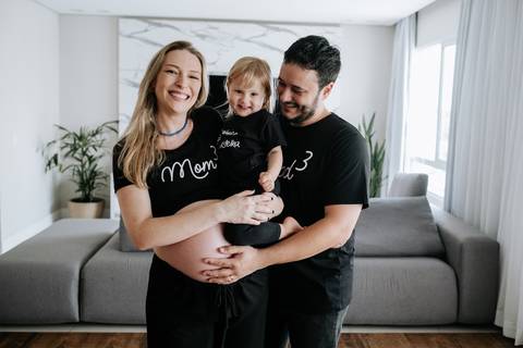Foto da família sorrindo na sala.'