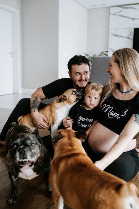 Foto da família reunida no chão com os pets.'