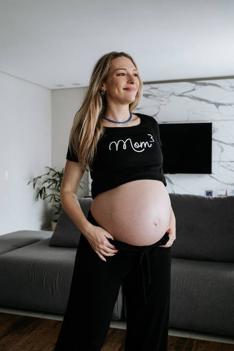 Foto em destaque da barriga de grávida de gêmeos.'