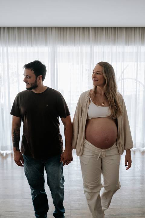 Foto do casal sorrindo de mãos dadas.'