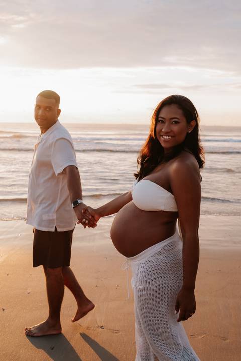 Foto do casal de mãos dadas  em frente ao sol.'