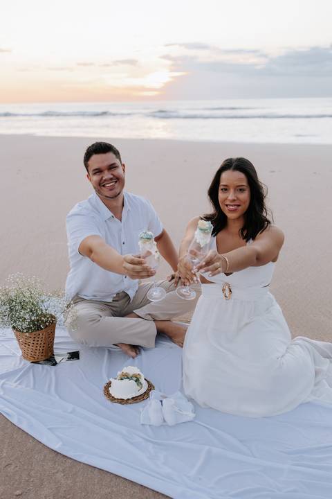 oto do casal brindando com as taças sujas com a cor que revelou o sexo do bebê.'