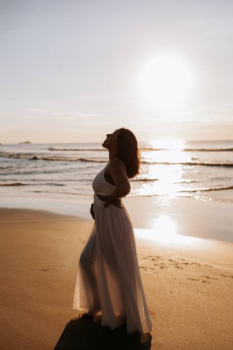 Foto da silhueta da gestante olhando para o céu no amanhecer.'