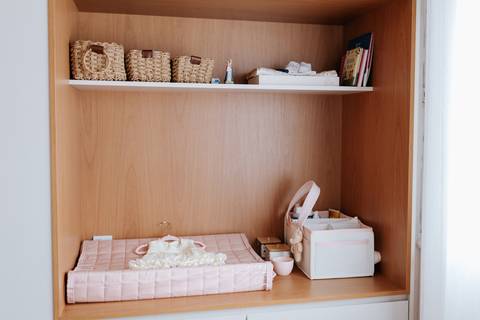 Foto da prateleira com trocador e itens de higiene do enxoval.'