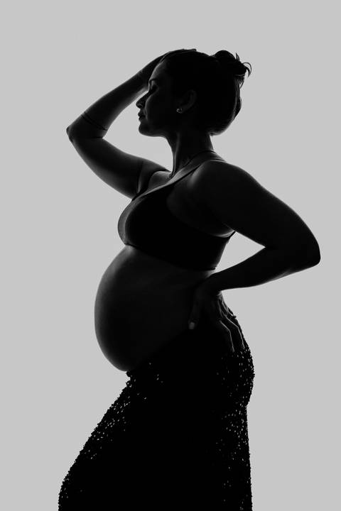 Foto em preto e branco da silhueta da gestante em estilo artístico e minimalista.'