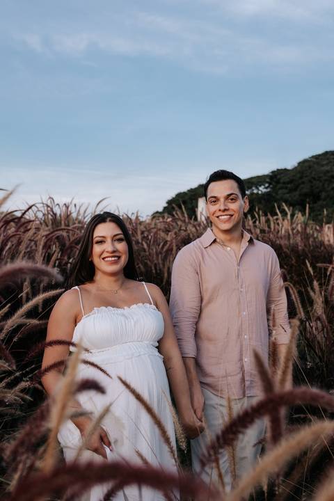 Foto aproximada do casal sorridente em ensaio gestante documental.'