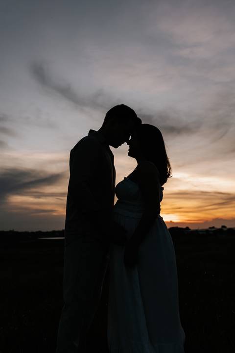 Foto da silhueta do casal encostando as testas em momento íntimo.'