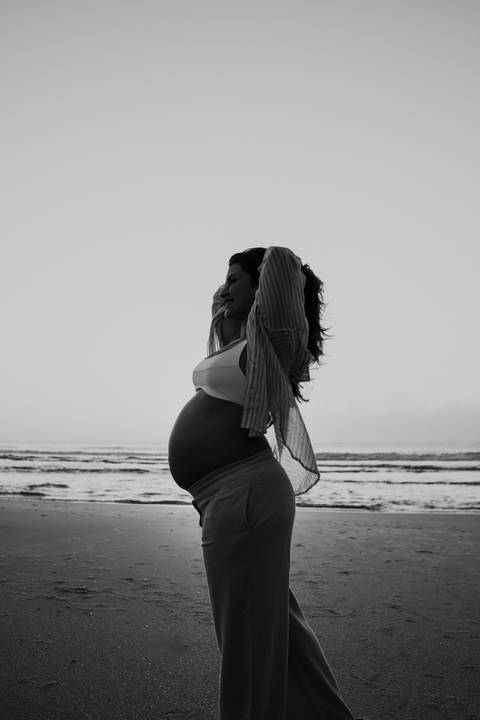 Foto em preto e branco da silhueta da gestante realçando o perfil da gravidez.'