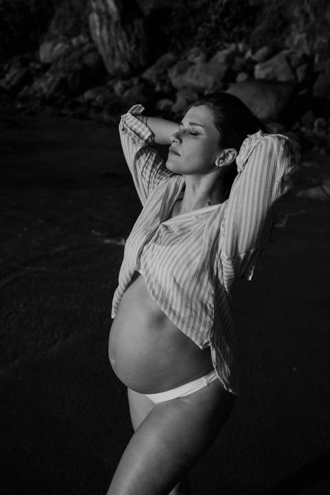 Foto em preto e branco da gestante em momento de paz.'