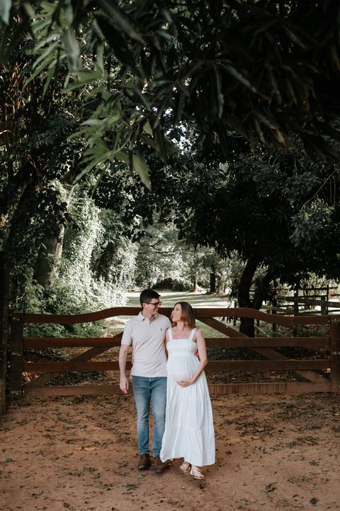 Foto do casal abraçados pela estrada da fazenda.'