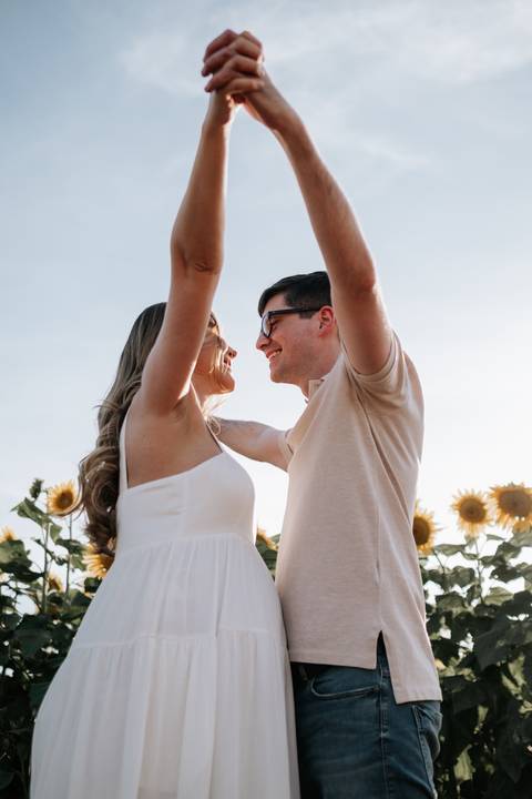 Foto do casal comemorando e sorrindo com os braços erguidos.'