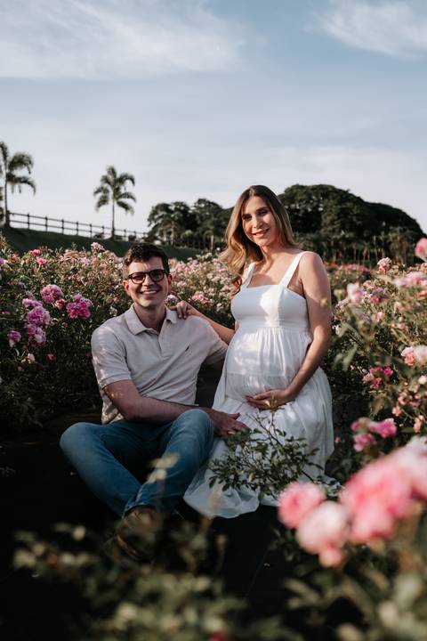 Foto do casal sentado no campo de flores.'