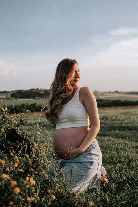 Foto de perfil da gestante contemplando o horizonte.'