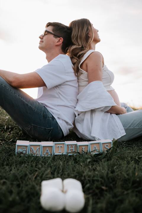 Foto do casal de costas um para o outro com o nome do bebê à frente.'