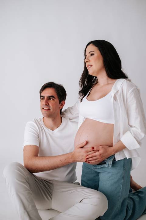 Foto do casal sentado interagindo durante a sessão fotográfica.'