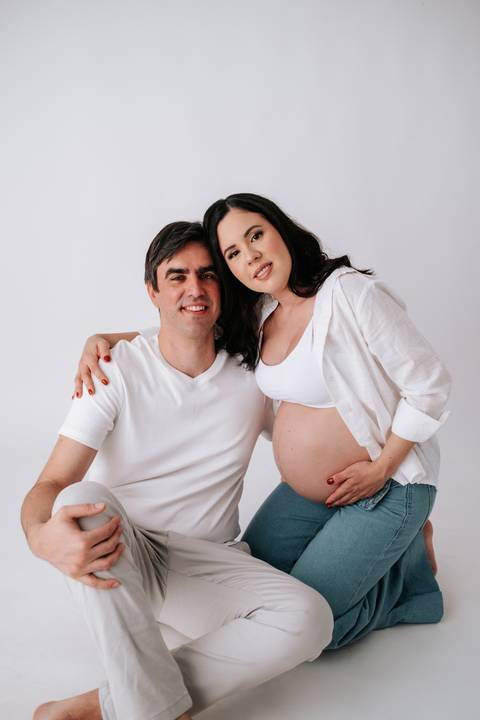 Foto do casal sorridente abraçado em momento afetivo.'