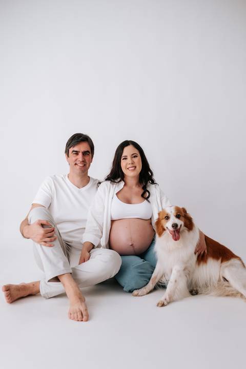 Foto da família completa com o cão de estimação no estúdio.'