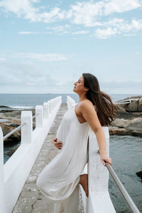 Foto aproximada da gestante com olhos fechados e vento no rosto.'