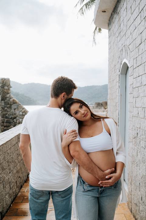 Foto da gestante encostando o rosto no ombro do parceiro.'