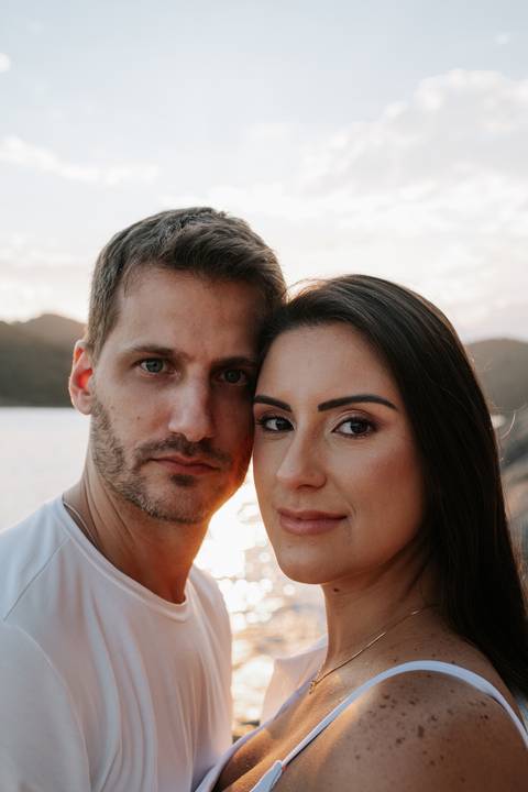 Close do casal com os rostos próximos sob a luz dourada do entardecer.'