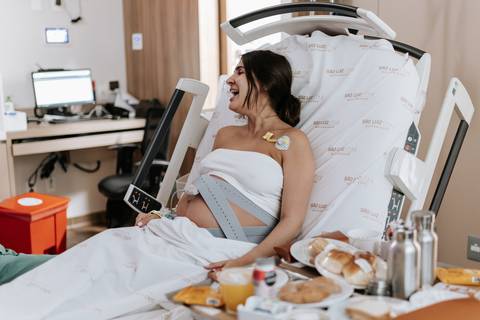 Foto da gestante sorrindo durante o café da manhã na maternidade.'