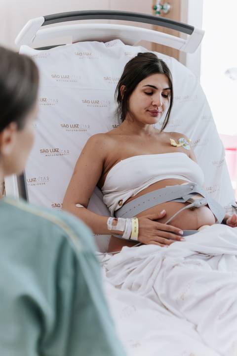 Foto aproximada da barriga com cintas de monitoramento fetal.'