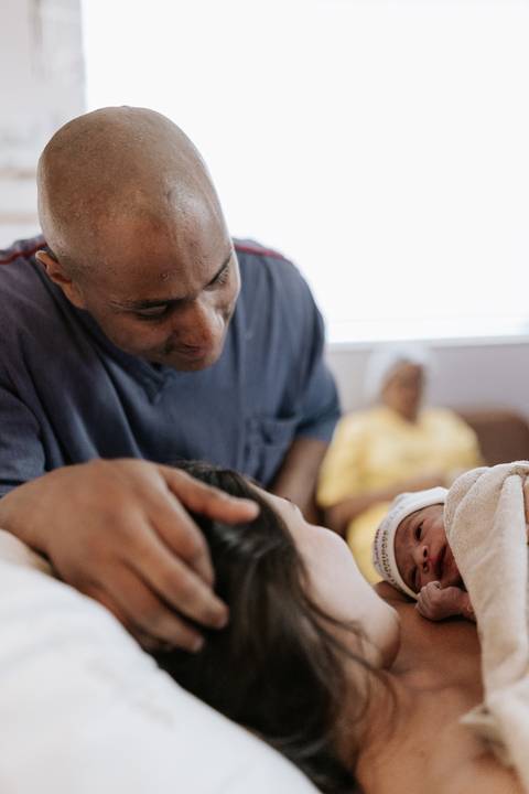 Foto do pai conhecendo a bebê logo após o nascimento.'