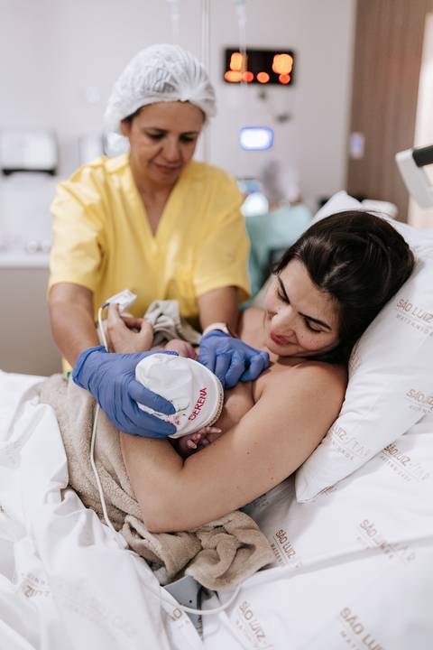 Foto da equipe de enfermagem orientando na primeira mamada.'