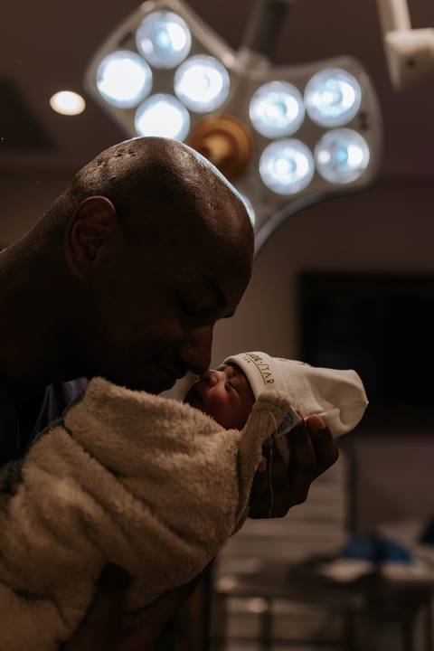 Foto aproximada do pai encostando o nariz na bebê em momento de carinho.'