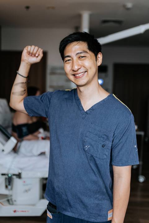 Foto do pai vibrando e comemorando após o nascimento no hospital.'