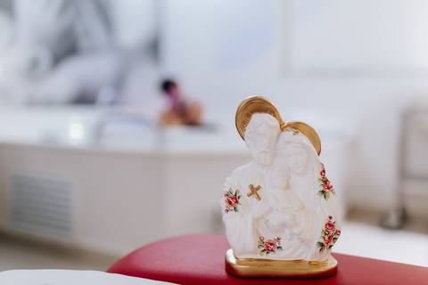 Foto de detalhe de imagem religiosa no centro da sala de parto.'
