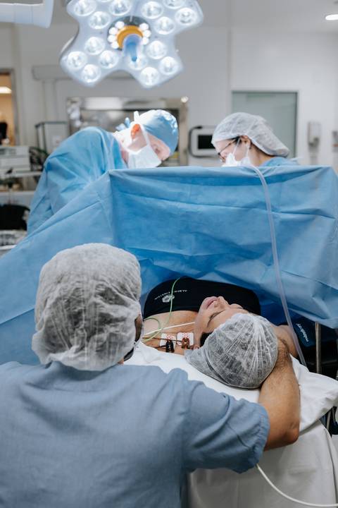 Foto da equipe médica realizando o parto dos bebês.'