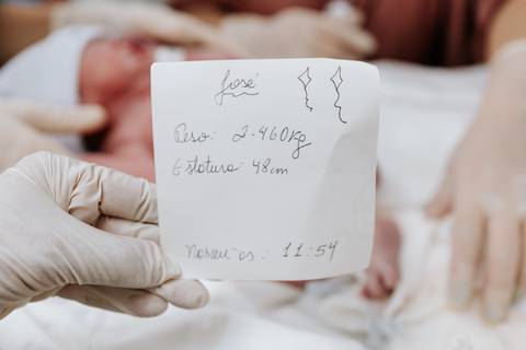 Foto da ficha de nascimento com dados de peso e estatura de um dos bebês.'